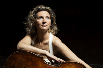 Portrait de face d'Oph&eacute;lie Gaillard, une main pos&eacute;e sur son violoncelle