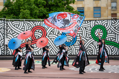 Six danseurs de yosakoi en kimono de sc&egrave;ne, agitant des ombrelles color&eacute;es et un drapeau