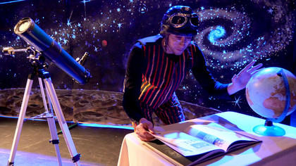 Un astronaute dans l'espace consultant un livre, avec une grande lunette avec ses c&ocirc;t&eacute;s