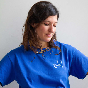 La dj Sharouh en tee-shirt bleu, l'air pensif, vue de face