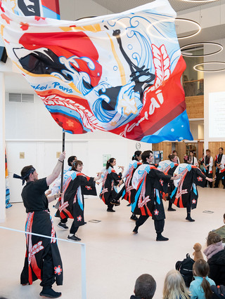 Danseurs de Yosakoi en costume traditionnel, agitant un drapeau color&eacute;, sc&egrave;ne &agrave; l'int&eacute;rieur