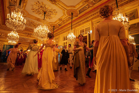 Femmes dansant dans un salon richement d&eacute;cor&eacute;, habill&eacute;es en costume de style Premier Empire